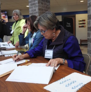 From left, Patricia Miran, Carolyn Dwyer and Faye Rafferty, election inspectors, assist voters with casting their ballots in Tioga County, N.Y.