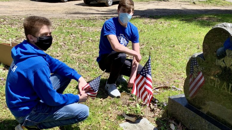 Photos: Student athletes place flags on veteran graves